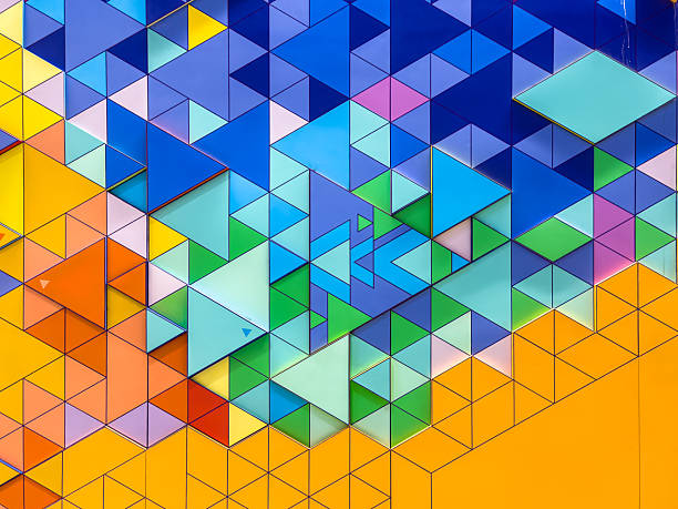 This image captures a striking abstract geometric design composed of tessellated triangles. The composition features a dynamic color gradient that transitions smoothly from warm, bright yellows and oranges in the bottom left corner to cool, deep blues, teals, and purples in the top right. The pattern includes triangles of various sizes, with some panels appearing raised or layered to create a subtle 3D relief effect. This adds texture and depth to the vivid mosaic, resulting in a modern and energetic aesthetic.