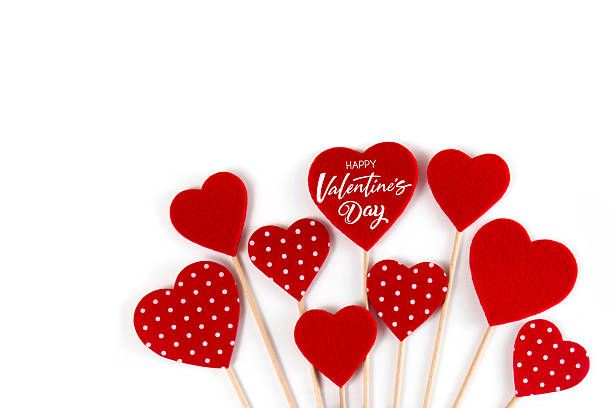 Hand made red felt hearts with wooden sticks inside of a white pocket design paper with Valentine’s day message
