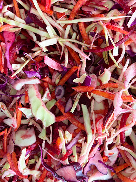Image of making coleslaw salad with sliced purple cabbage, carrot, onion, and sauerkraut, fresh ingredients for homemade recipe