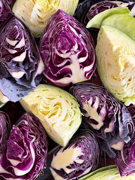 Image of chopping fresh green and purple cabbage, preparing sliced cabbage for cooking, colorful vegetable ingredients on cutting board