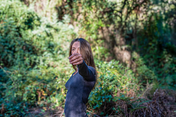 Woman reaching out with an outstretched hand, connecting with nature in a forest