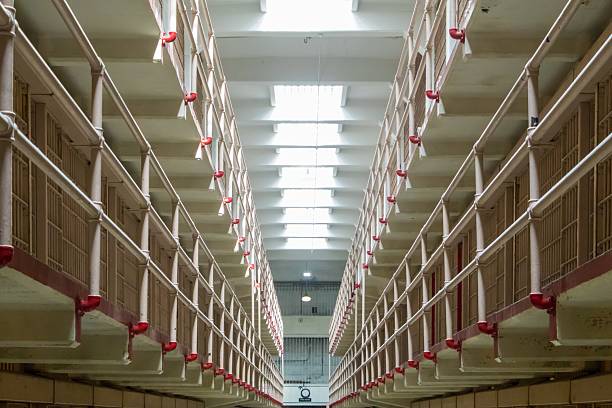 A long corridor runs between stacked cell tiers inside the former prison. Depth and repetition emphasize institutional order and confinement. Suitable for justice and architecture themes.
