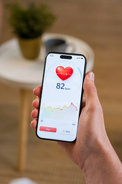 istock Hand holding smartphone displaying heart rate tracking app 2259856474