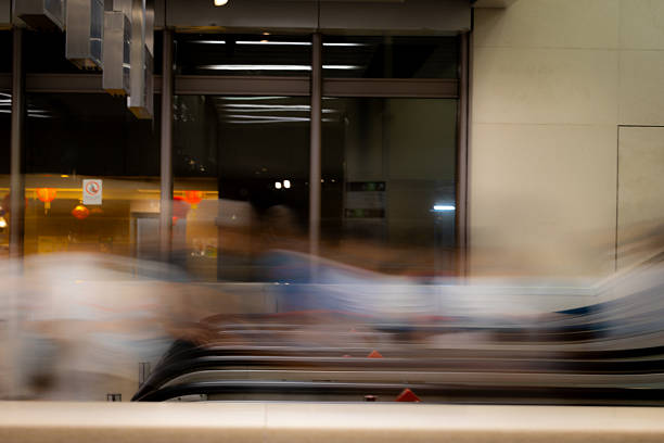 Commuters taking escalators in an MTR station, taken in long exposure.