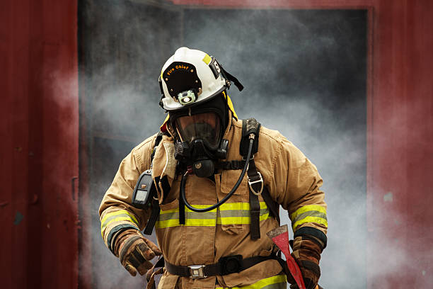 tehran, iran - july 14, 2017 - equipped firefighter trying to put out a fire with a fire extinguisher