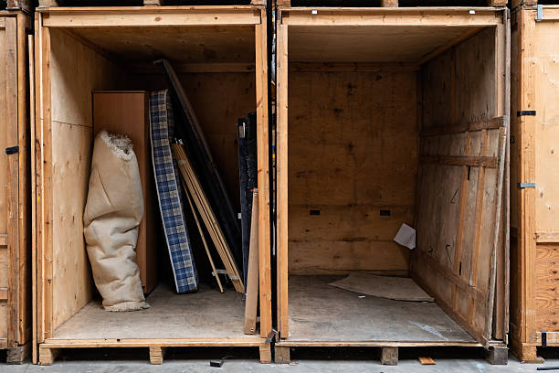 Open wooden storage crates showing furniture and empty storage units inside warehouse. Concept of self storage, removals, archiving, inventory control, and secure storage