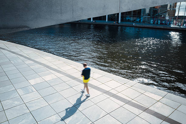 high angle view motion blurred man walking  in the modern government district at spree river at sunny day
