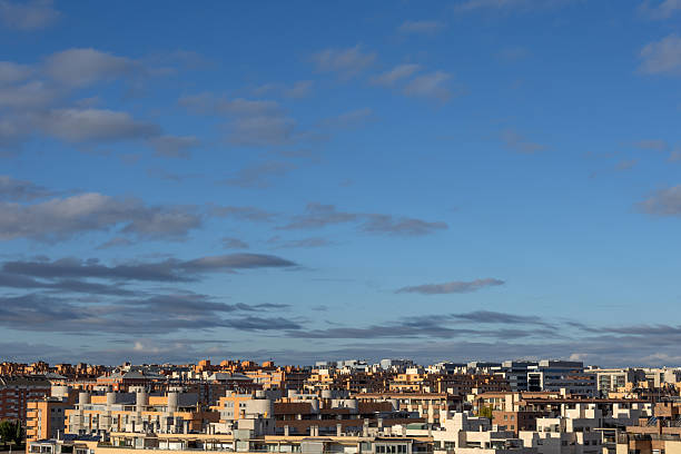 Madrid. Spain. Urban skyline presenting a dense residential cityscape with buildings and apartments under a bright blue sky with scattered clouds, showcasing a daytime view of madrid, spain