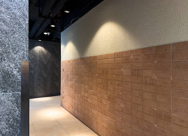A sleek, modern corridor featuring textured walls and warm lighting, creating an inviting atmosphere. The space is minimalistic and stylish, suitable for commercial or residential use.