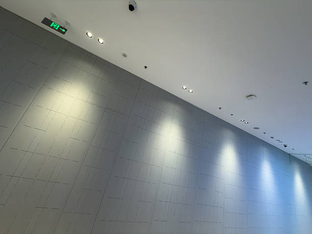 Contemporary interior space featuring recessed lighting on a gray wall, creating a clean and sophisticated atmosphere. Potential for commercial or architectural presentations.