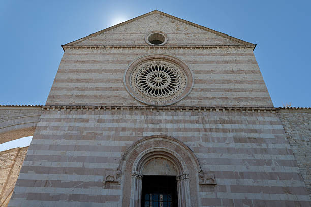 Basilica di Santa Chiara facade in Assisi, Italy, with distinctive striped architecture and a large rose window
