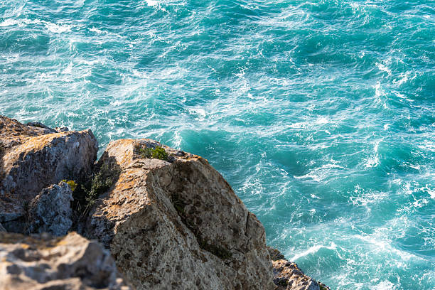 Looking down at the waves crashing against the rocks