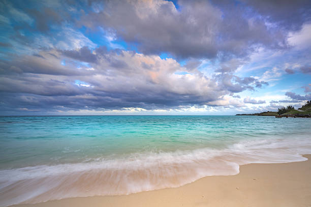 Soft Wave Lapped on Empty Sandy Beach With Colorful Sky and Clouds Over Wavy Sea with Copy Space