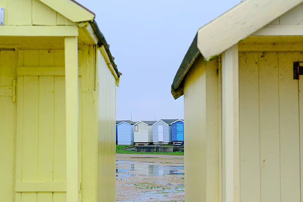 Brightlingsea, Essex, UK - 02 FEB 2025 - Bright colored beach huts on a rainy day at the British Seaside.