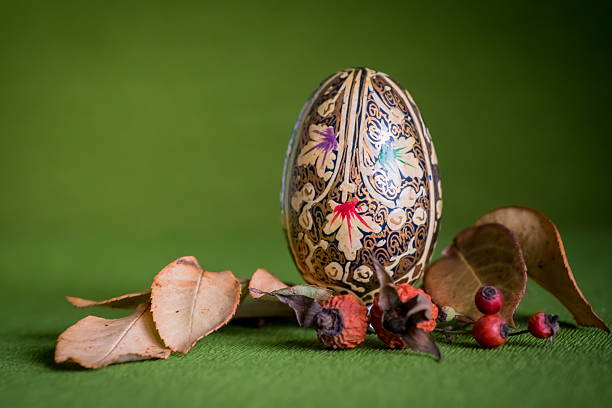 Easter arrangement with a painted egg and colorful leaves