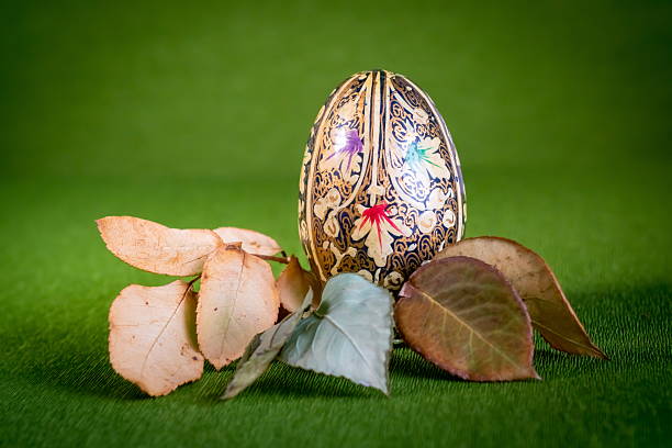 The Woman Artist in the studio paints Easter eggs in the colors of the Ukrainian flag