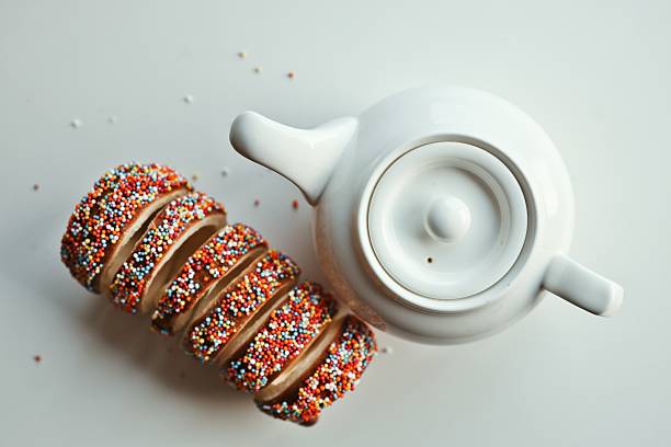 Sweet Kurtos Kalacs Slices with Colorful Sprinkles Next to a White Teapot