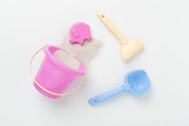 Cute toys for playing with sand on color background, top view