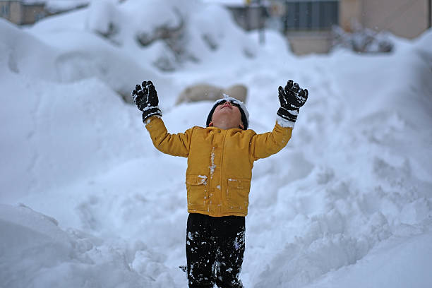 Little boy plays in snowing