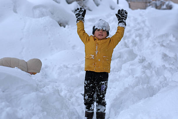 Little boy plays in snowing