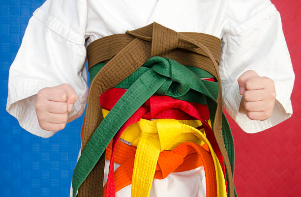 Colorful karate belts on wooden background, closeup