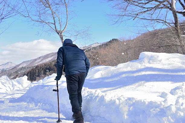 Seniors doing rehabilitation using walking sticks on snowy roads