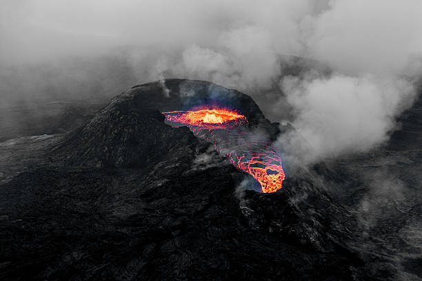 Fagradalsfjall volcano in Iceland erupting with incandescent molten lava flowing from its crater, creating a dramatic and powerful display of natural geological forces and raw power
