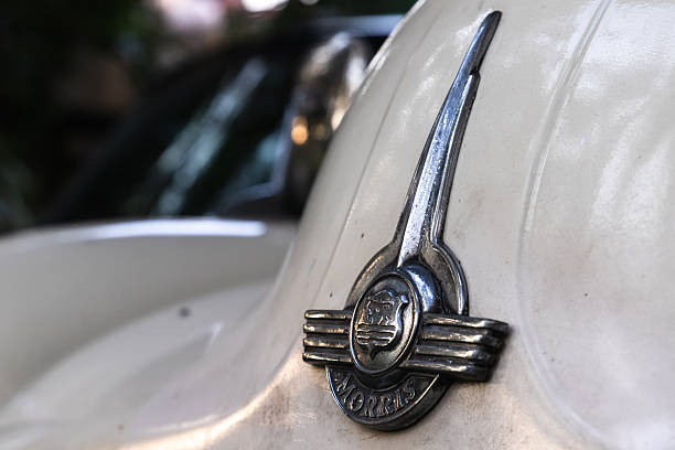 London, UK - November 30, 2021: Old cromed Morris Minor car logo is on white car hood. This is a retro British economy family car