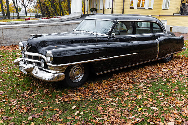 St-Petersburg, Russia - October 26, 2025: Shiny black Cadillac Fleetwood vintage car with chrome accents is parked on the lawn. Perfect for vintage car, nostalgia, and lifestyle imagery