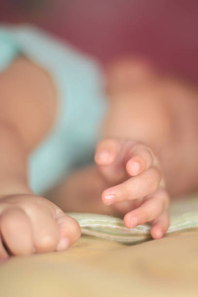 Intimate soft-focus image of baby hands resting together, symbolizing calm, innocence, comfort, parenting, early childhood and gentle family moments