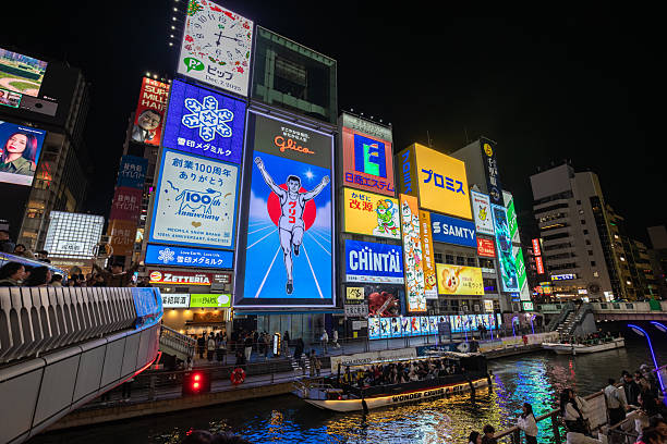 Kyoto, Japan - December 04, 2025: Dotonbori, Osaka, Japan. Iconic cityscape at night, featuring dazzling neon billboards, the Glico running man, bustling crowds, and illuminated boats on the canal.