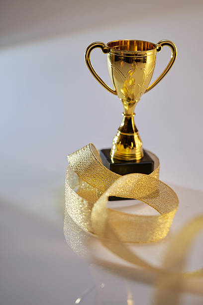 gold colored trophy with gold ribbon