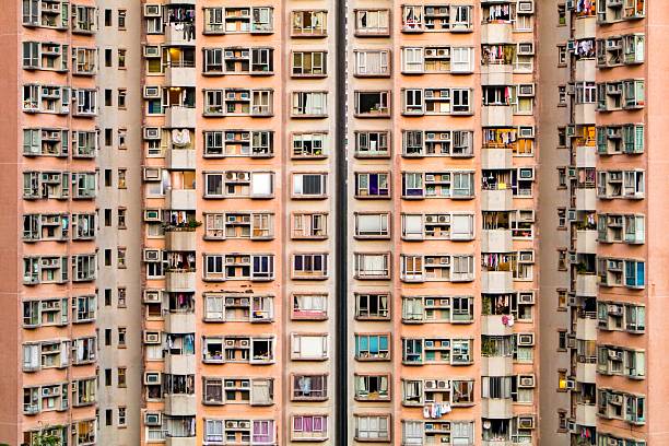 Repetitive residential apartment facade pattern in Hong Kong, highlighting extreme density, vertical housing and urban repetition.