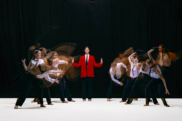 Employee group in rapid motion blur converging toward calm leader in red jacket. Concept of workplace culture, behavioral patterns, organizational response, team engagement and internal dynamics.