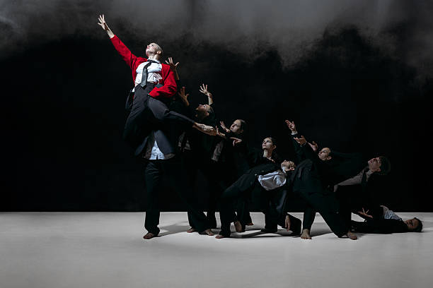 istock Striking group formation with raised gestures around elevated figure in red jacket creating bold promotional imagery 2260031520