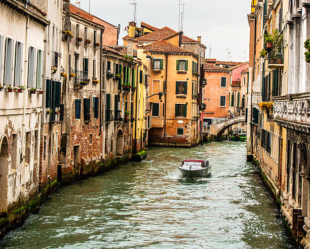 Boat Sailing Down Old Canal In Venice, Italy