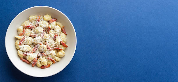 Gnocchi in a creamy sauce with bacon and cheese. Italian cuisine.