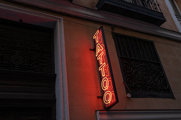 istock Red neon tattoo sign glowing on building wall 2260065647