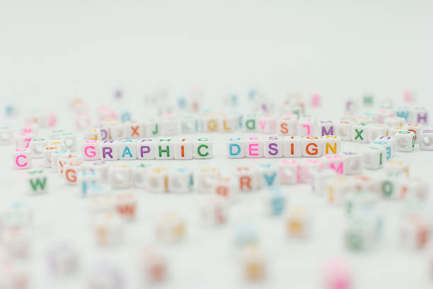 Colorful letter blocks are scattered on a white surface. Some blocks form the words graphic design, showcasing a creative activity in progress. This setting is ideal for brainstorming ideas.