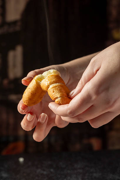 Hands breaking warm cheese filled pastry for a snack