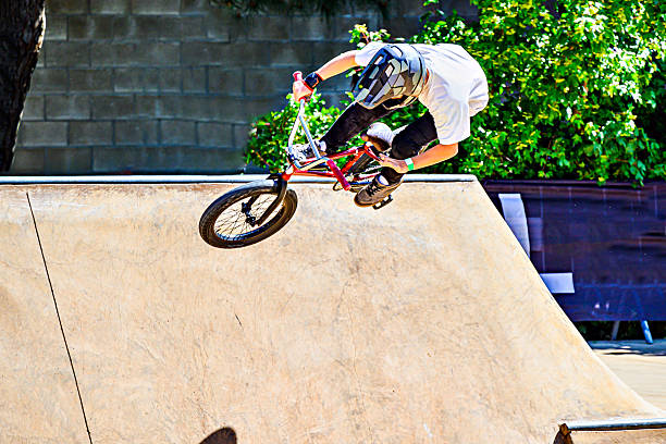 Kyiv, Ukraine - June 15, 2022: Contract Square. Bmx biker performing tricks and stunts training in city park. Jump on bmx bike in action