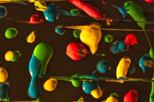 Dynamic abstract photography created with long exposure and colorful chemical paints on a dark background. Vibrant streaks of yellow, red, and green create a modern, energetic texture perfect for creative design projects.