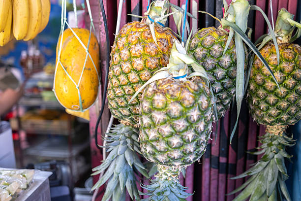 Photography of pineapple on market stall 