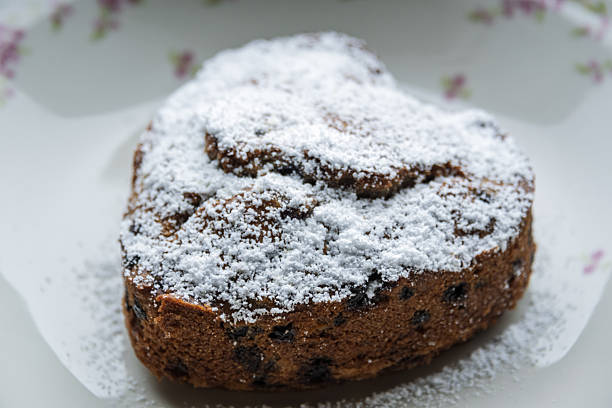 a blueberry cake in heart shape on an old-fashioned porcelain plate with floral pattern