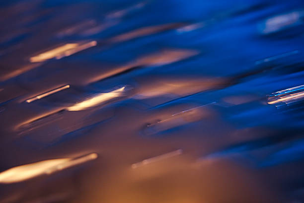 Abstract texture featuring golden light spirals on turquoise water, captured via long exposure. Peaceful, dreamy, and fluid visual. High-quality natural shot ideal for spa, wellness, meditation, and modern decoration projects.