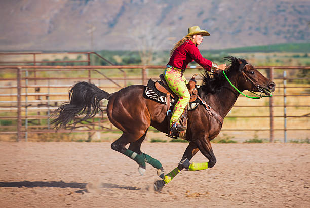Cowgirl riding a horse in a rodeo arena. Barrel race practice at empty rodeo arena.