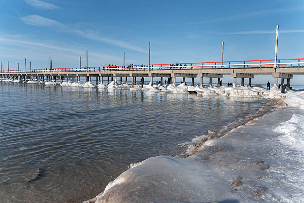 istock Frozen Pier with Ice Sculptures and People on a Clear Winter Day 2260110982