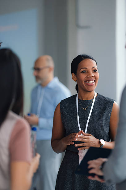 istock Confident Woman Presenter Smiles At Conference, Engaging Audience With Lanyard And Professional Attire 2260129366