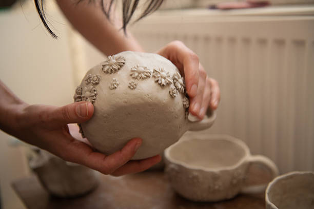 Hands holding a handmade ceramic piece during the making process, artisan craft and slow living concept.