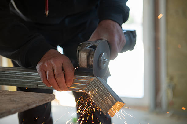 Close-up of angle grinder cutting a metal stud/profile during renovation, industrial work and fabrication concept.
